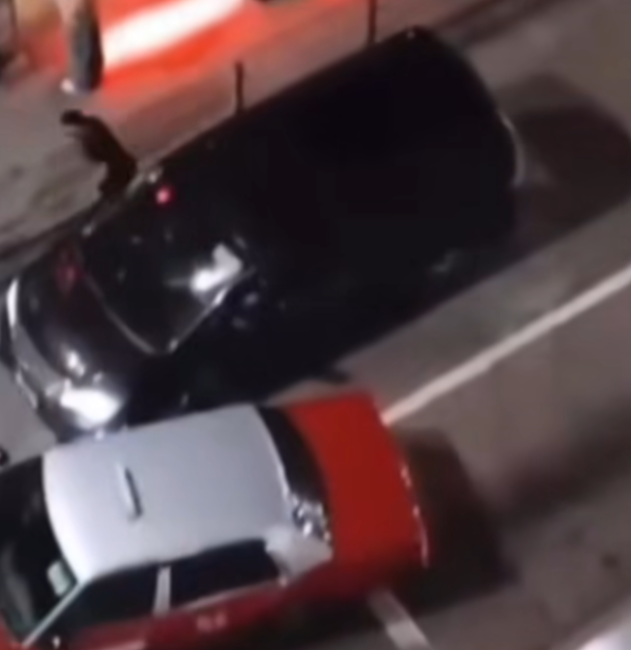 隨後七人車前座女乘客開門,試圖勸阻男子喝止「冷靜啲啦你!喂!」,男司機返回私家車並再次嘗試離開現場,惟的士於班馬綫前再次「閘車」擋住七人車去路,兩車更疑擦撞,男子再度下車。(影片截圖)