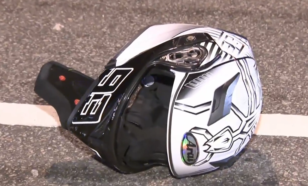 事發後,涉事電單車前輪與車身斷開兩截,地上遺下頭盔。(有線新聞畫面)