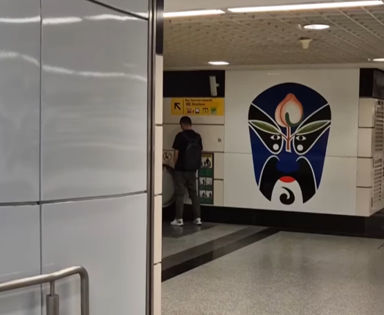 一名中國籍男子在新加坡歐南園地鐵站內,向一條扶手電梯小便。(影片截圖)