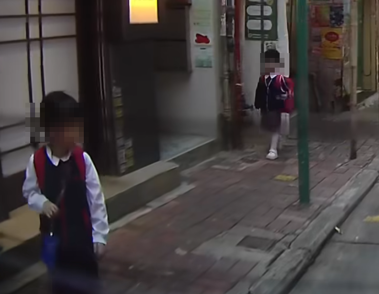 兩名穿幼稚園校服的年幼女童與一名疑為母親的黑白間條衫婦人,由灣仔道步行進入普樂里,惟婦人未有拖着兩女童,只顧自己先行,兩女童從後跟着。 (車cam L(香港群組)FB)