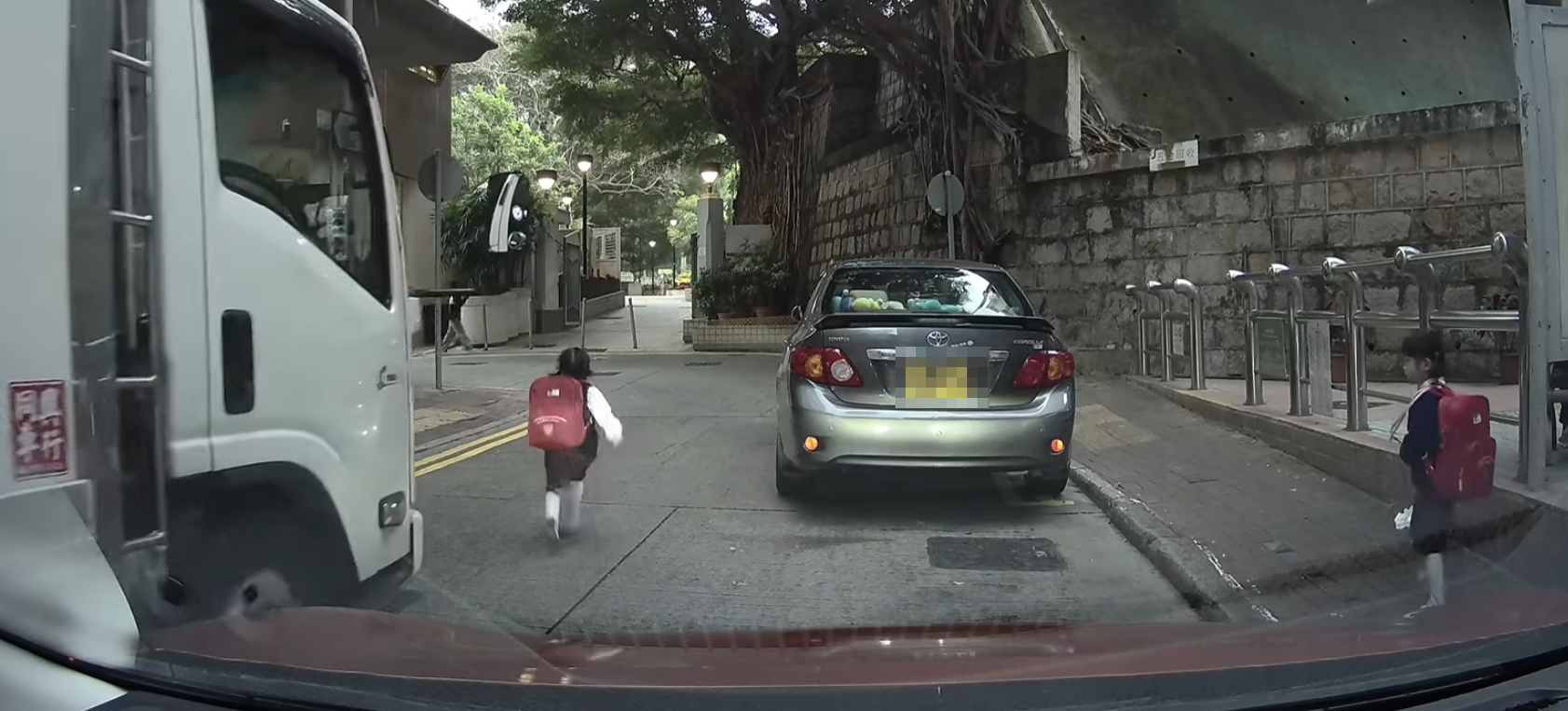幸貨車司機速度不快及時煞車,女童亦察覺貨車駛至,奔跑往對面行人路尋找婦人 (車cam L(香港群組)FB)