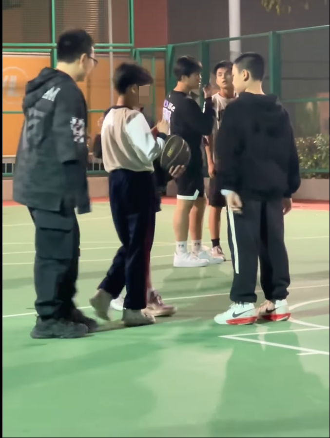 右面的黑衣男童把香煙遞給另一身穿校服的男童。(片段截圖)