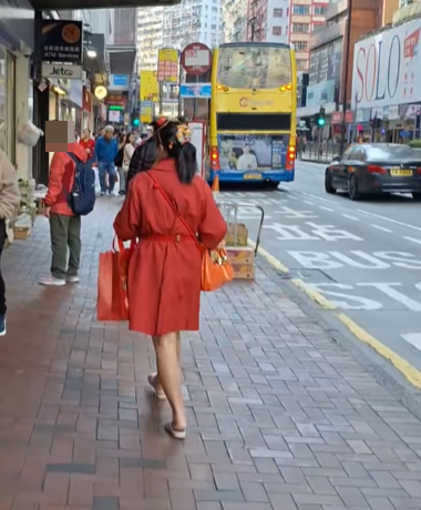 北角有大媽穿大紅色連身裙,以「人肉利是封」打扮不斷向途人詢問「有無利是啊?」(影片截圖)