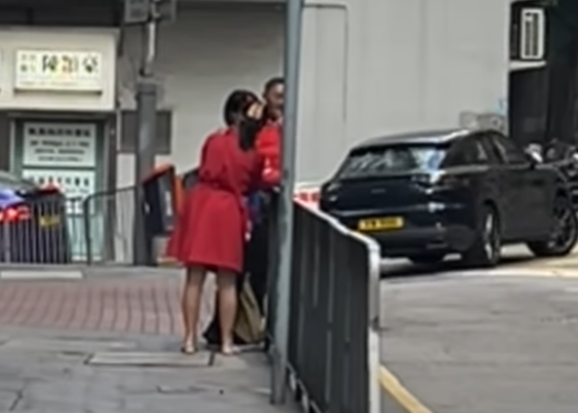 北角有大媽穿大紅色連身裙,以「人肉利是封」打扮不斷向途人詢問「有無利是啊?」(影片截圖)