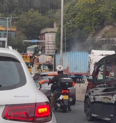 一輛貨櫃車沿獅子山隧道往九龍方向行駛,駛出管道後不久,車輛貨櫃突然起火冒煙。 馬路的事 (即時交通資訊台)