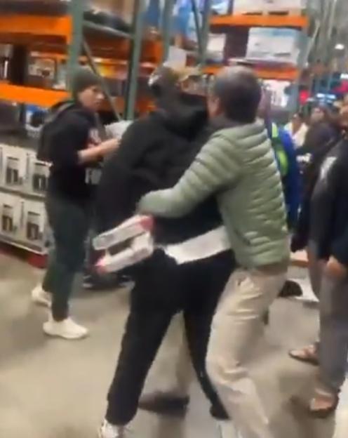 —名身穿綠色外套男子在爭奪組合包時,與另一名拿著兩盒卡牌的年輕男子纏鬥一起。(X)