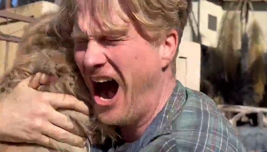 他緊抱著愛犬情緒激動,並開心地歡呼走著,他感謝上天的恩賜。(X)