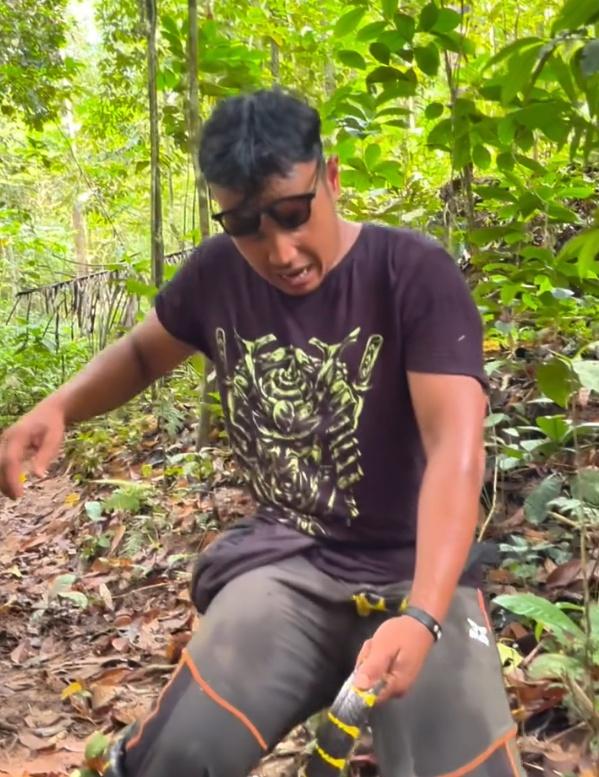 由於蛇沒有要鬆口的意思,使得他滿頭大汗,臉上露出痛苦表情,只能痛苦坐在地上。(IG)