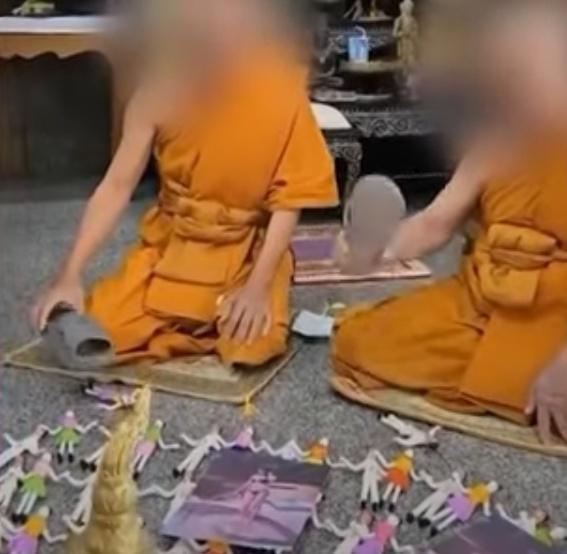 僧侶一邊唸經、一邊用鞋擊打人形紙偶,旁邊還放有一名身穿泳衣的年輕女子相片。(YouTube)