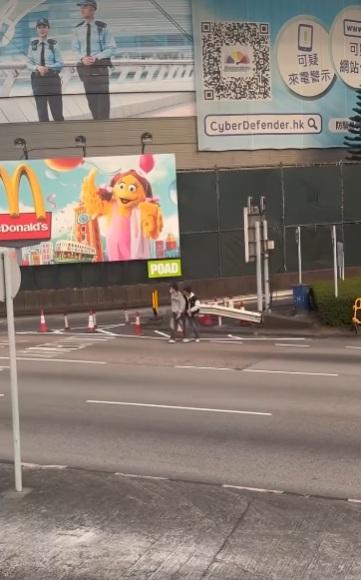 兩男在紅隧出口過馬路要職員帶走。(網片截圖)