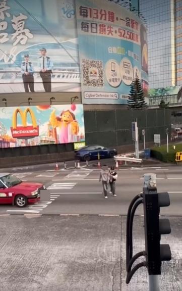 兩男在紅隧出口過馬路要職員帶走。(網片截圖)