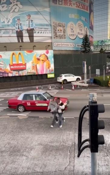 兩男在紅隧出口過馬路要職員帶走。(網片截圖)