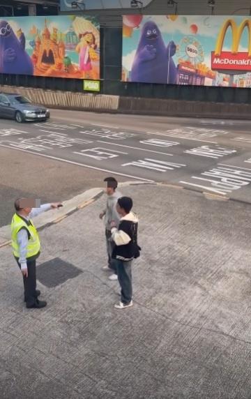 兩男在紅隧出口過馬路要職員帶走。(網片截圖)