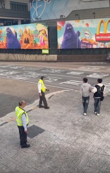 兩男在紅隧出口過馬路要職員帶走。(網片截圖)