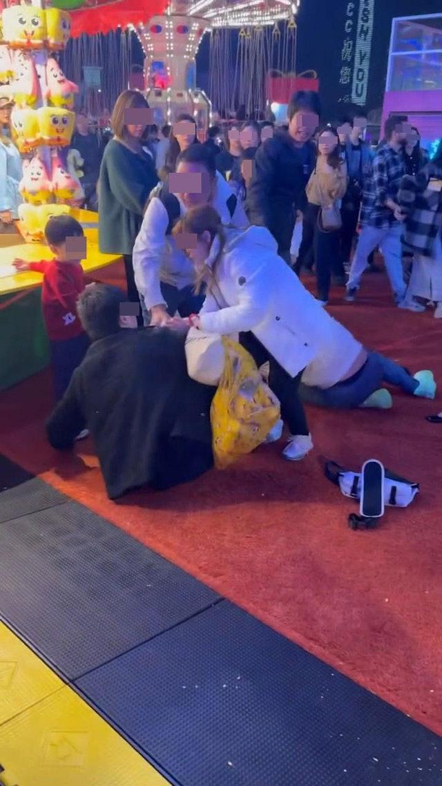 一名穿紅衣的男童目瞪口呆地看著,隨後被家長扯走。(網片截圖)