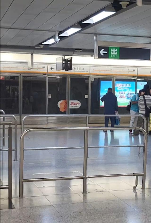 網民拍攝到一名中年漢在港鐵香港站月台上等車時食煙。(網片截圖)