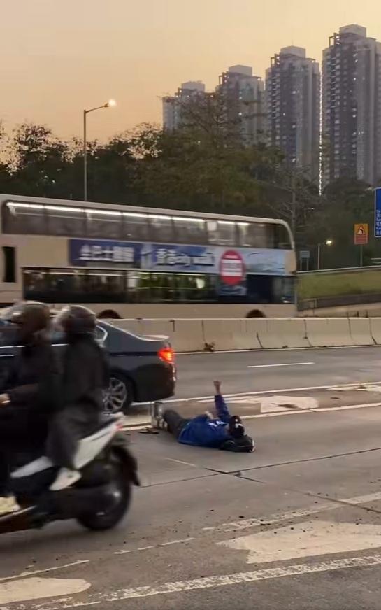 一名男子在青山公路近博愛醫院對開「躺平」,完全無視身邊熙來攘往的車輛。(網片截圖)