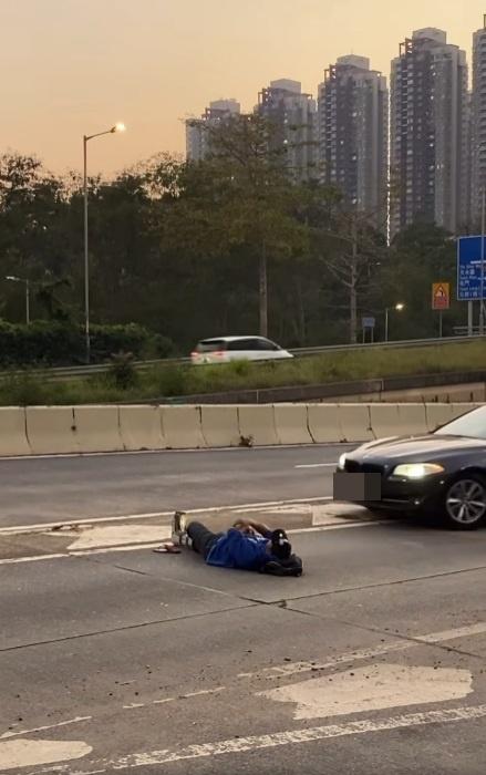 一名男子在青山公路近博愛醫院對開「躺平」,完全無視身邊熙來攘往的車輛。(網片截圖)