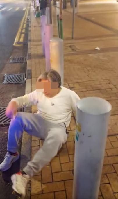 白衣男自知屈人不成,坐在地上。(網片截圖)