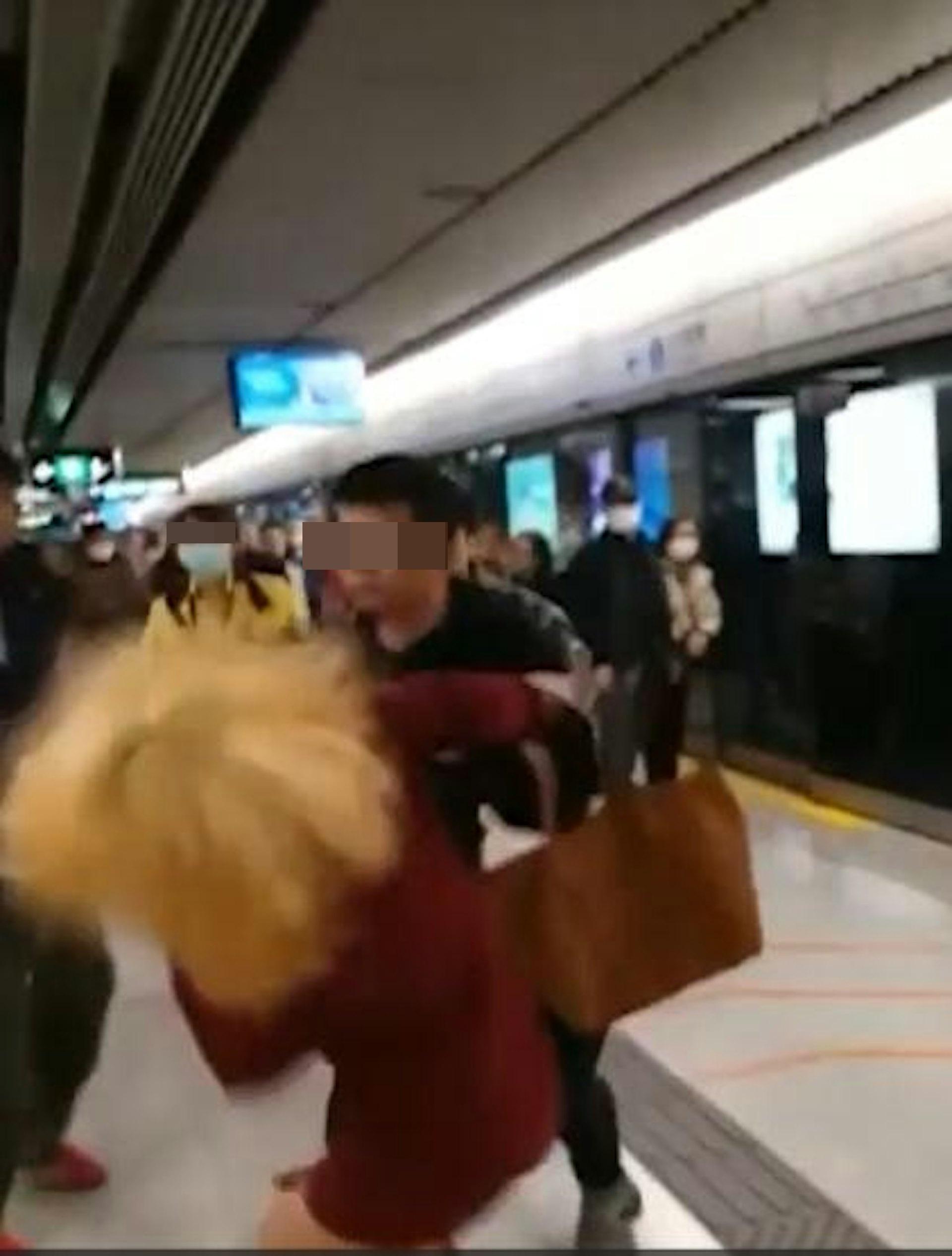 黑衣男怒火中燒,一拳擊中金髮女的頭部,令她當場倒地。(網片截圖)