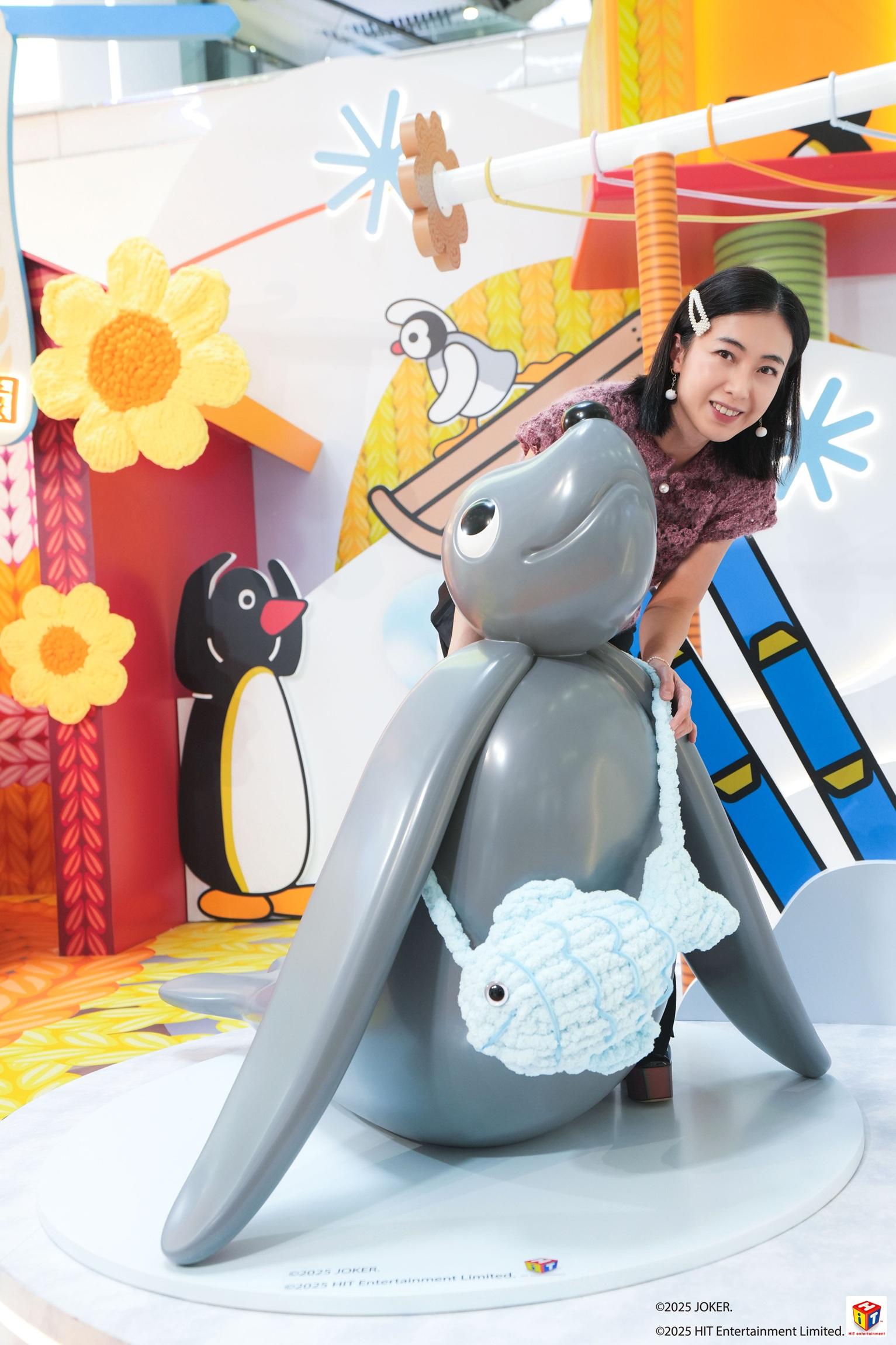 甘比把織物戴在公仔身上。