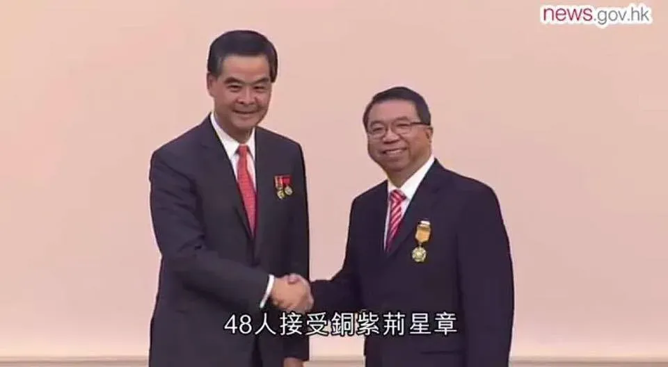 李家仁於2015年7月1日獲時任特首梁振英頒授銅紫荊星章。(政府新聞處影片截圖)