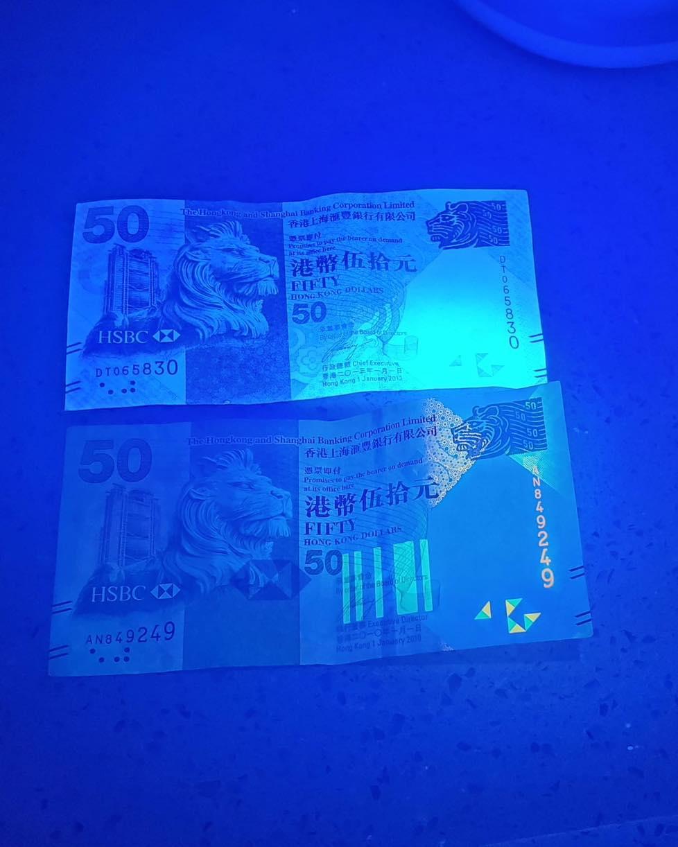 下方是真鈔,上方為假鈔。假鈔偽冒滙豐銀行鈔票,以「DT」編號開首,顏色明顯較暗啞,水印及金屬線模糊粗糙,紫外燈光照射下出現大片反光範圍。(騰駿的士管理公司fb)