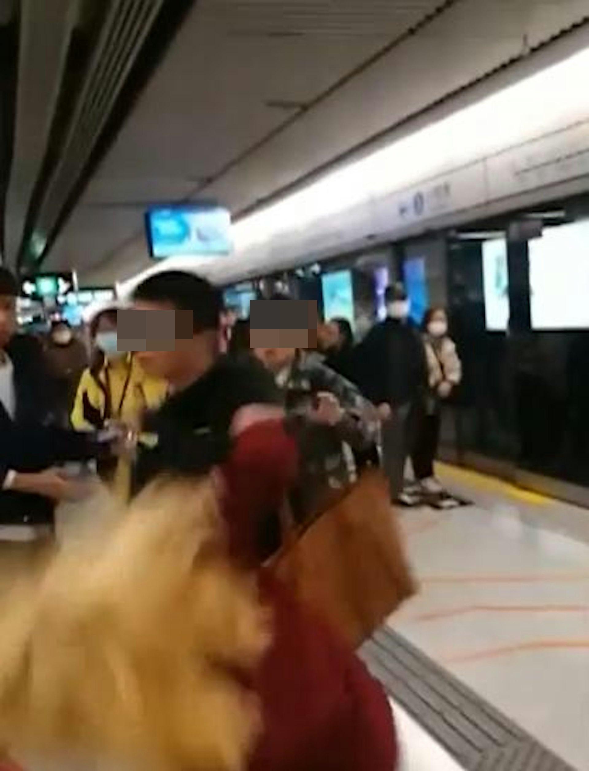 黑衣男怒火中燒,一拳擊中金髮女的頭部,令她當場倒地。(網片截圖)