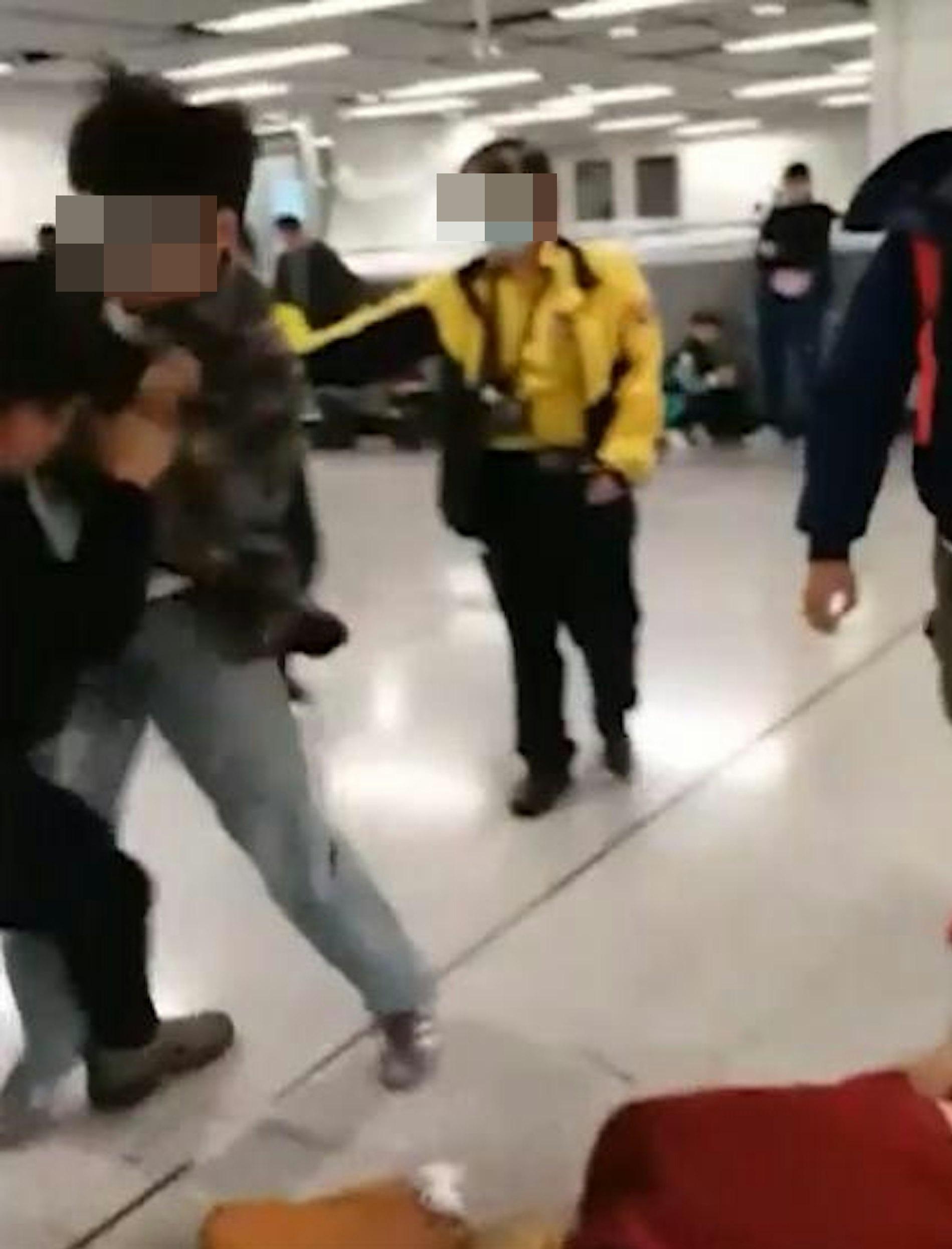 格仔男見狀立即與黑衣男展開肉搏,黑衣男卻試圖繼續攻擊金髮女。(網片截圖)