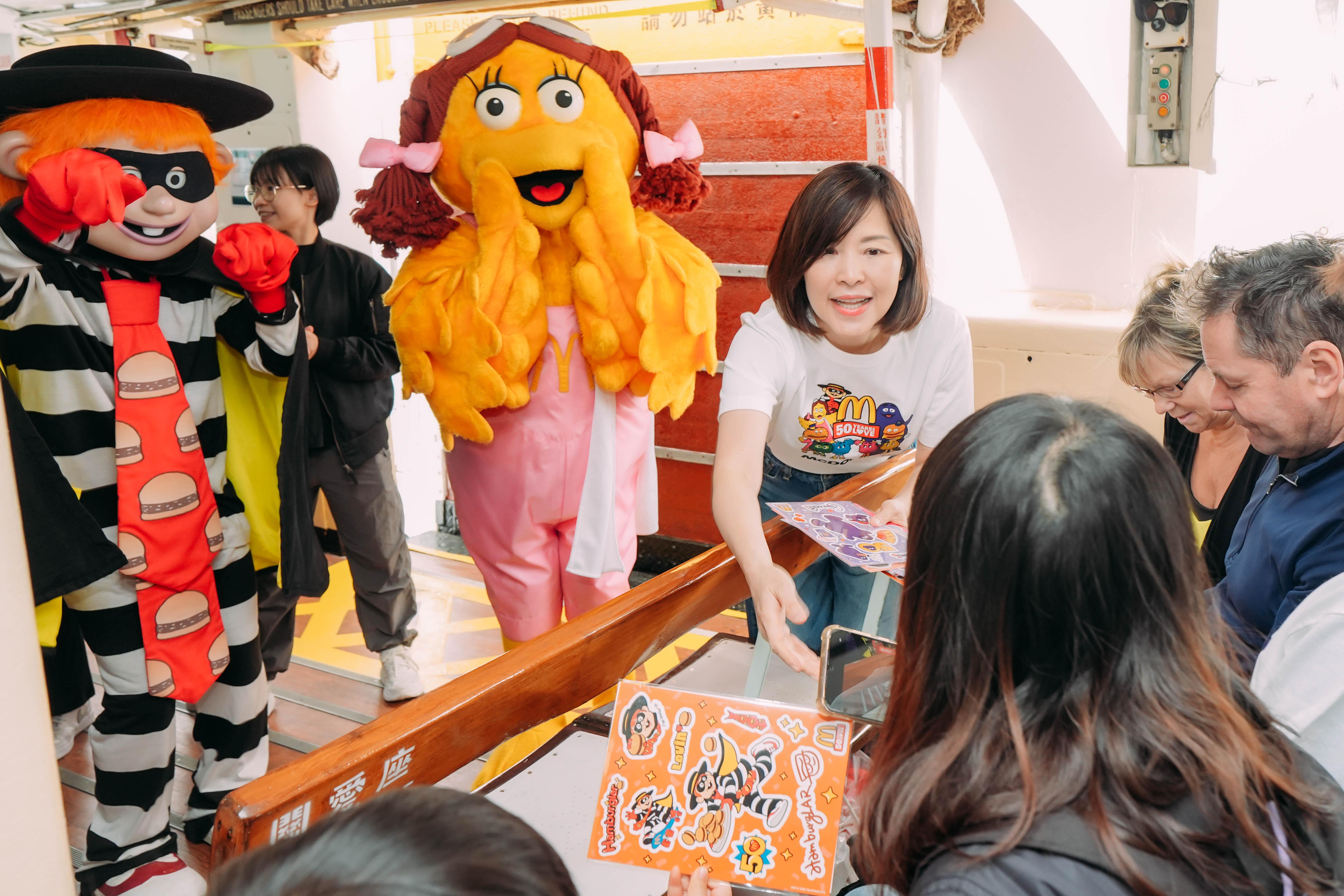 香港麥當勞行政總裁黎韋詩向小朋友派發 50 週年紀念小禮物,貼紙上印有深受大朋友、小朋友喜 愛的麥當勞樂園人物。