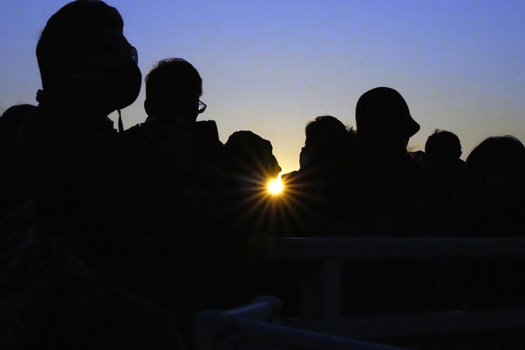 民眾聚集橫濱海岸迎接元旦日出。(美聯社)