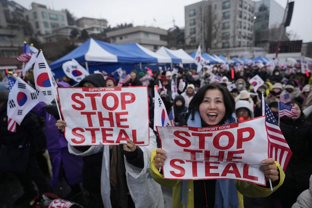 尹錫悅支持者周一續在總統官邸附近集會,反對彈刻尹錫悅。支持者展示「停止偷竊」抗議標語。(美聯社)