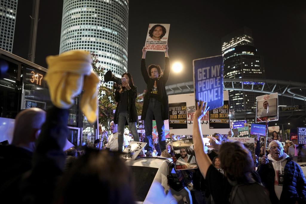 以色列與哈馬斯周三宣布達成停火協議後,以色列特拉維夫一批人筫家屬上街慶祝。(美聯社)