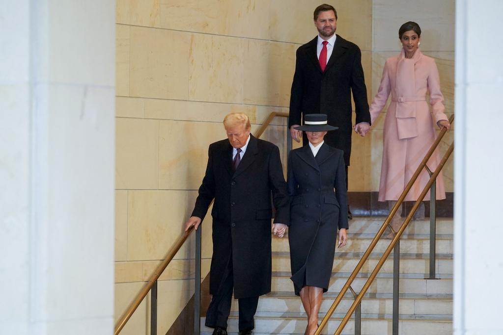 梅拉尼婭一身簡約型格的深藍修腰套裝,配襯同色系闊邊帽子,令人驚艷,尤其帽子遮臉帶出了疏離的美感。(美聯社)