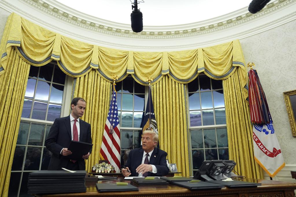 特朗普周一宣誓就任後回到白宮總統辦公室,簽署多項行政命令。(美聯社)