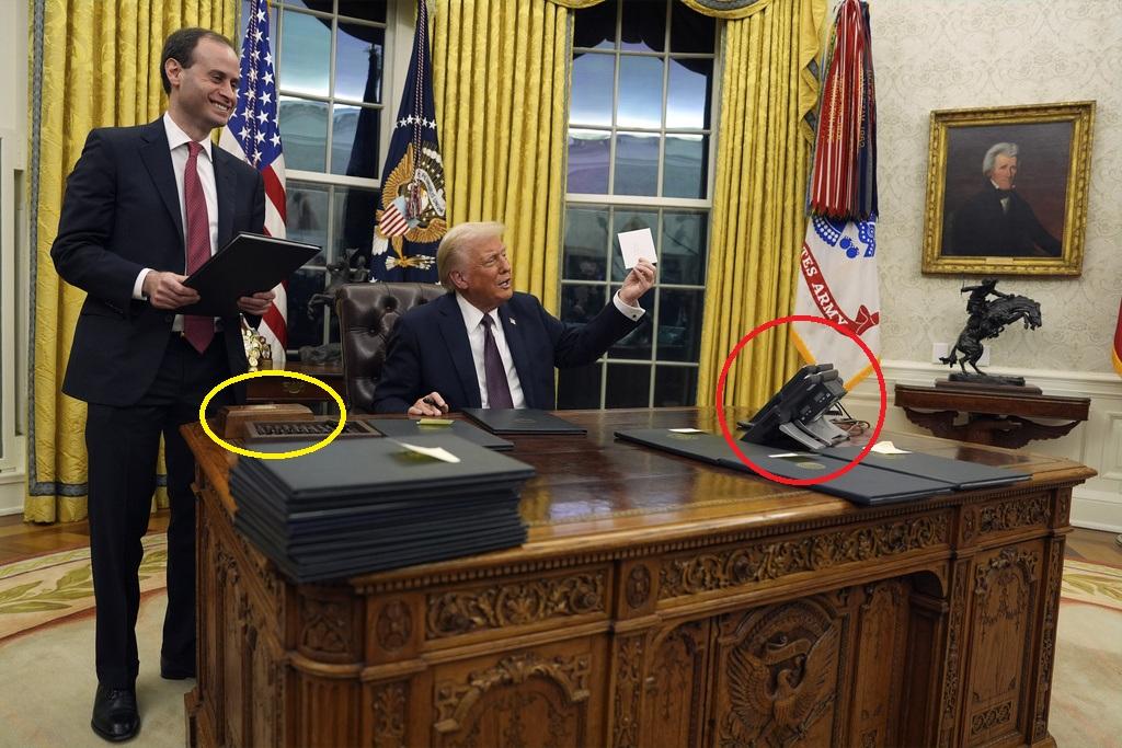 特朗普的右邊放著神秘按鈕,左邊放著幾個電話。(美聯社)