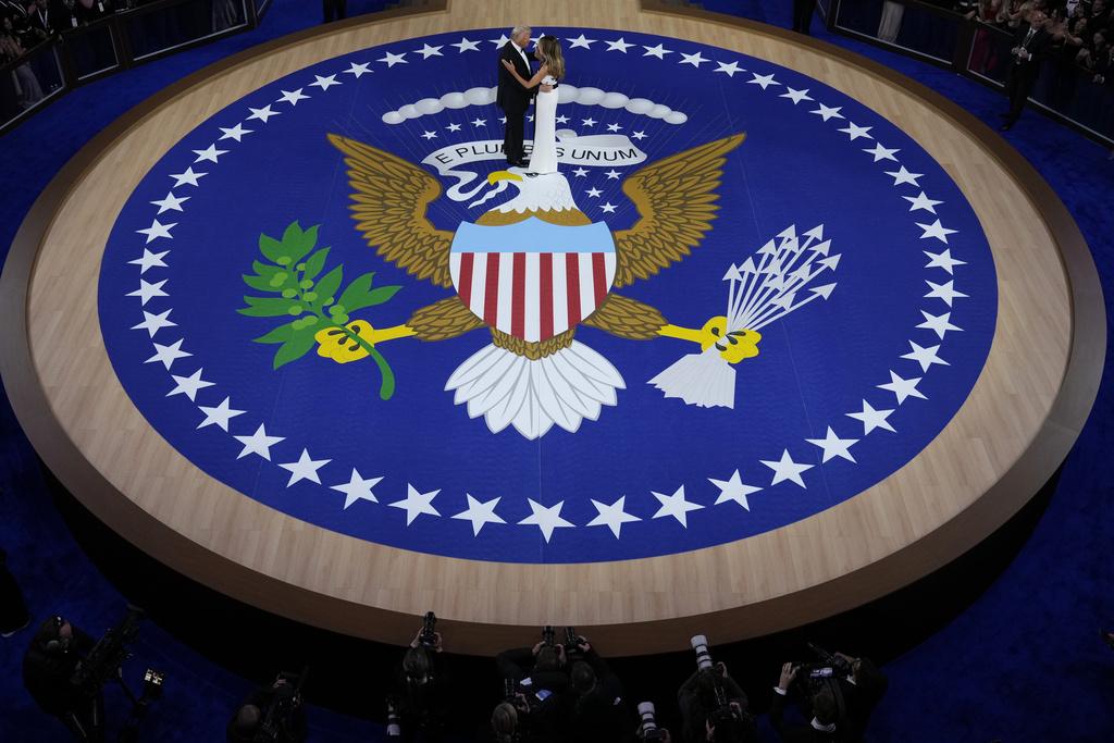 梅拉尼婭在晚上總統就職舞會穿著的露肩白底黑條帶連身禮服,與特朗普共舞。(美聯社)