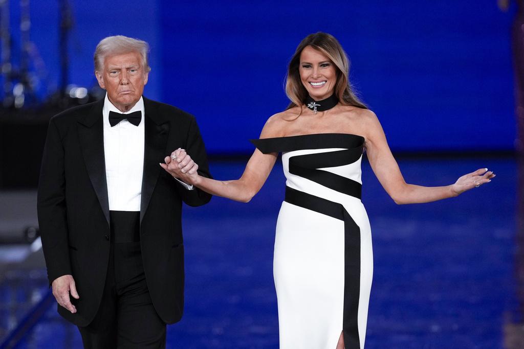 梅拉尼婭在晚上總統就職舞會穿著的露肩白底黑條帶連身禮服,展現另一種美態。(美聯社)