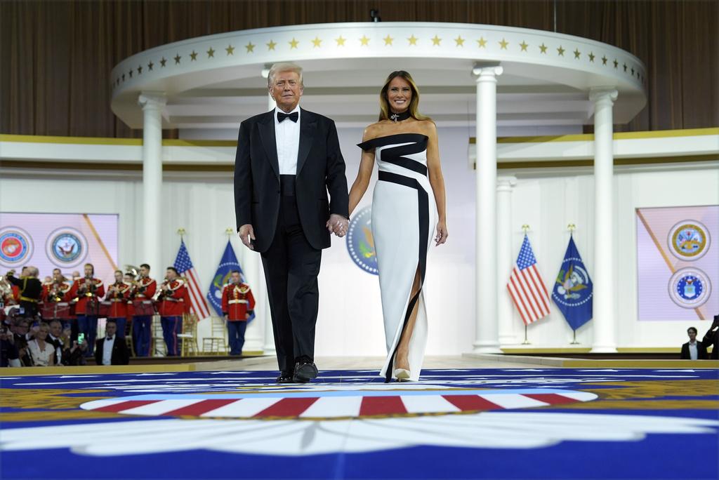 梅拉尼婭在晚上總統就職舞會穿著的露肩白底黑條帶連身禮服,展現另一種美態。(美聯社)