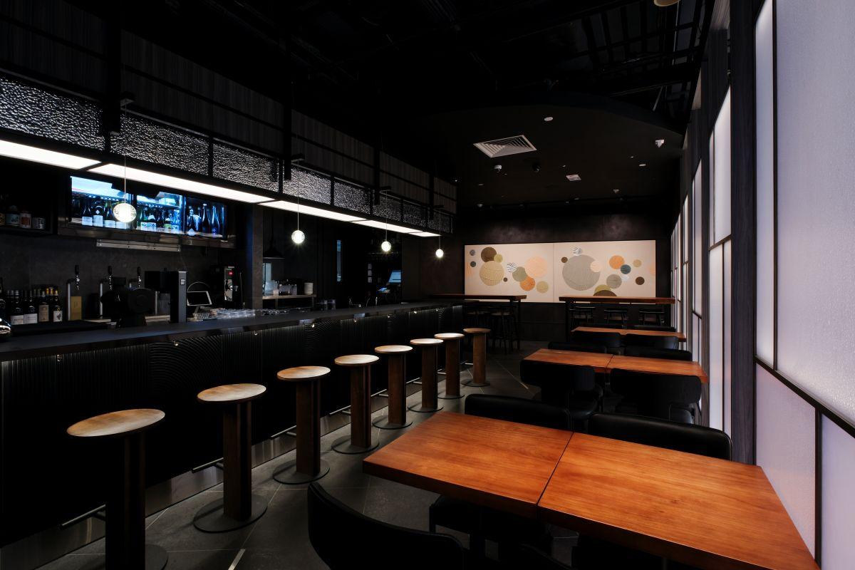 酒館內採用深邃低沉的炭灰色和溫暖的木質色調,配合柔和燈光,營造出神秘而又輕鬆的氣氛。