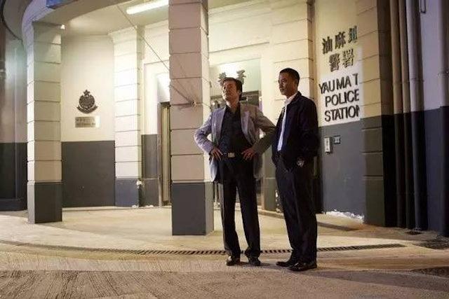 電影《黑社會》中,梁家輝(左)和任達華(右)在舊油麻地警署門口針鋒相對的一幕。(網上圖片)