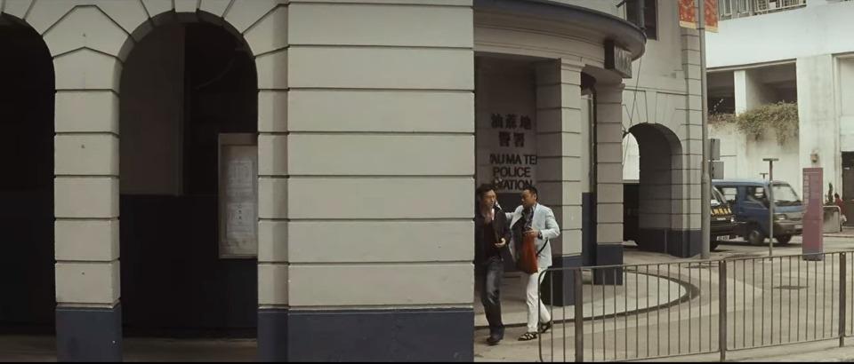 電影《奪命金》中,劉青雲飾演三腳豹(右)為兄弟籌保釋金時,陪着張兆輝(左)飾演的拜山華走出舊油麻地警署。(網上圖片)