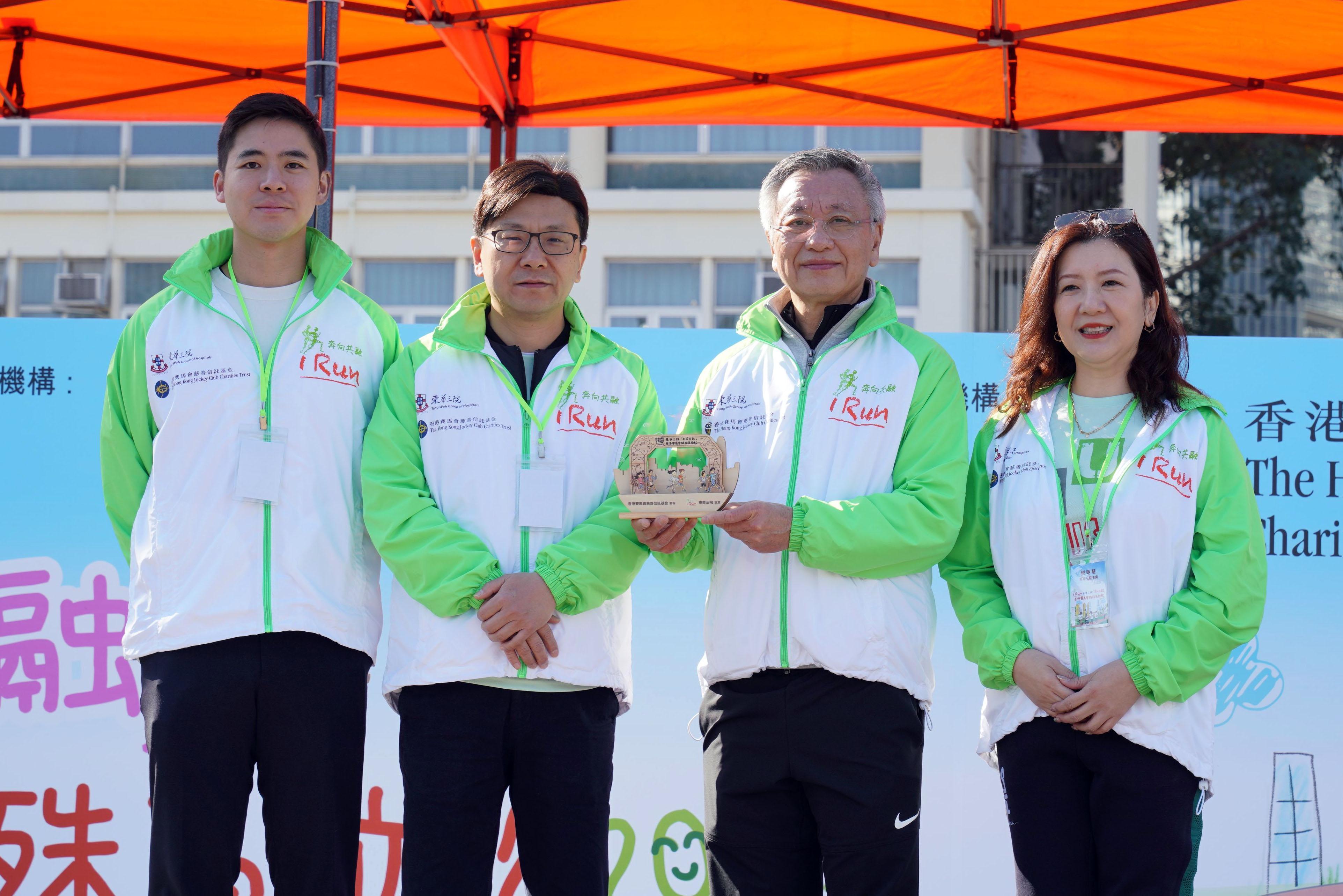 香港特別行政區政府勞工及福利局局長孫玉菡(左二)致送紀念品予馬會董事羅啟華 (右二),並由東華三院主席鄧明慧(右一)及東華三院第四副主席暨社會服務委員會 主任委員伍怡(左一)陪同。