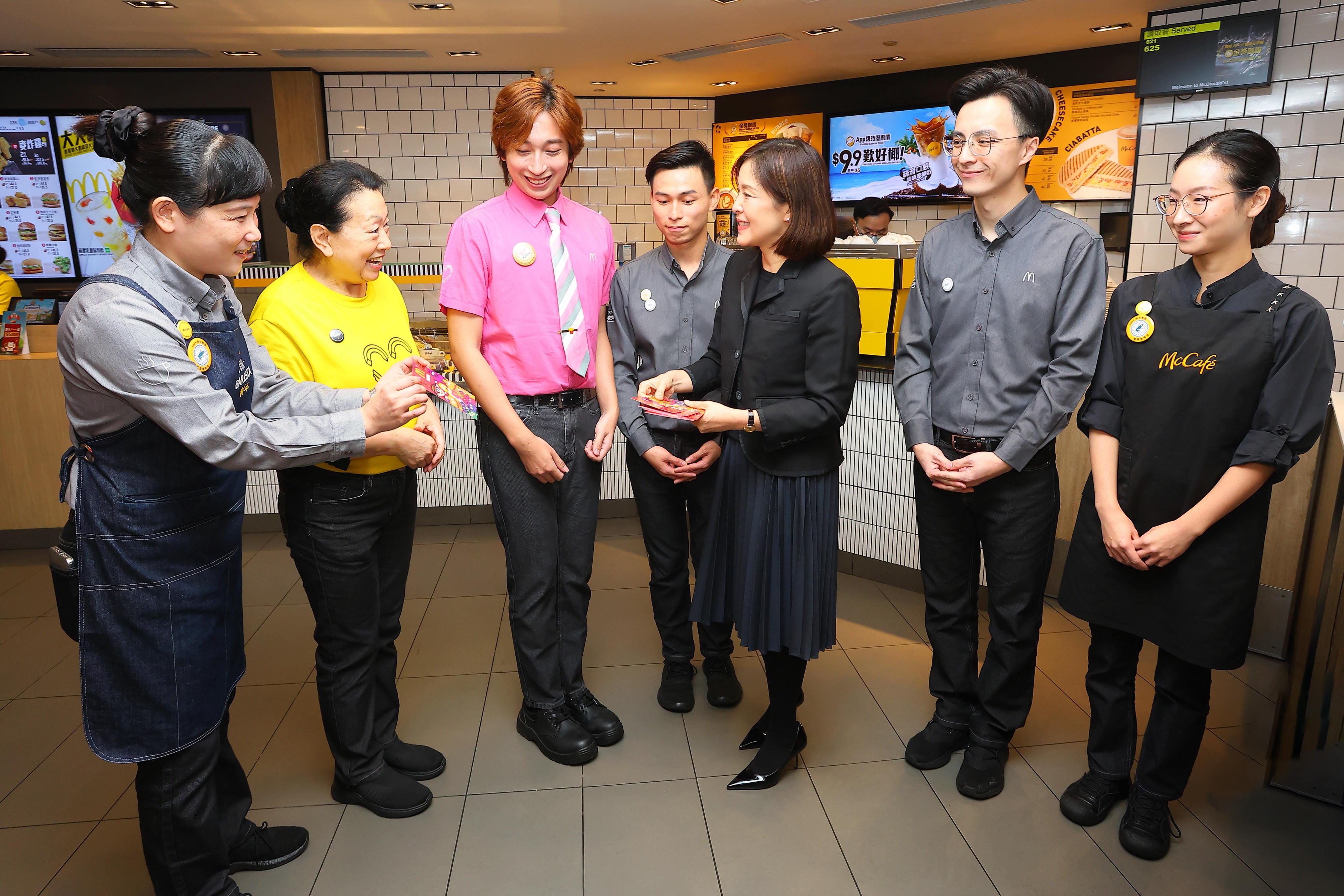 香港麥當勞行政總裁黎韋詩(右三)代表公司派發港幣 1,000 元 50 週年新春利是。(香港麥當勞)