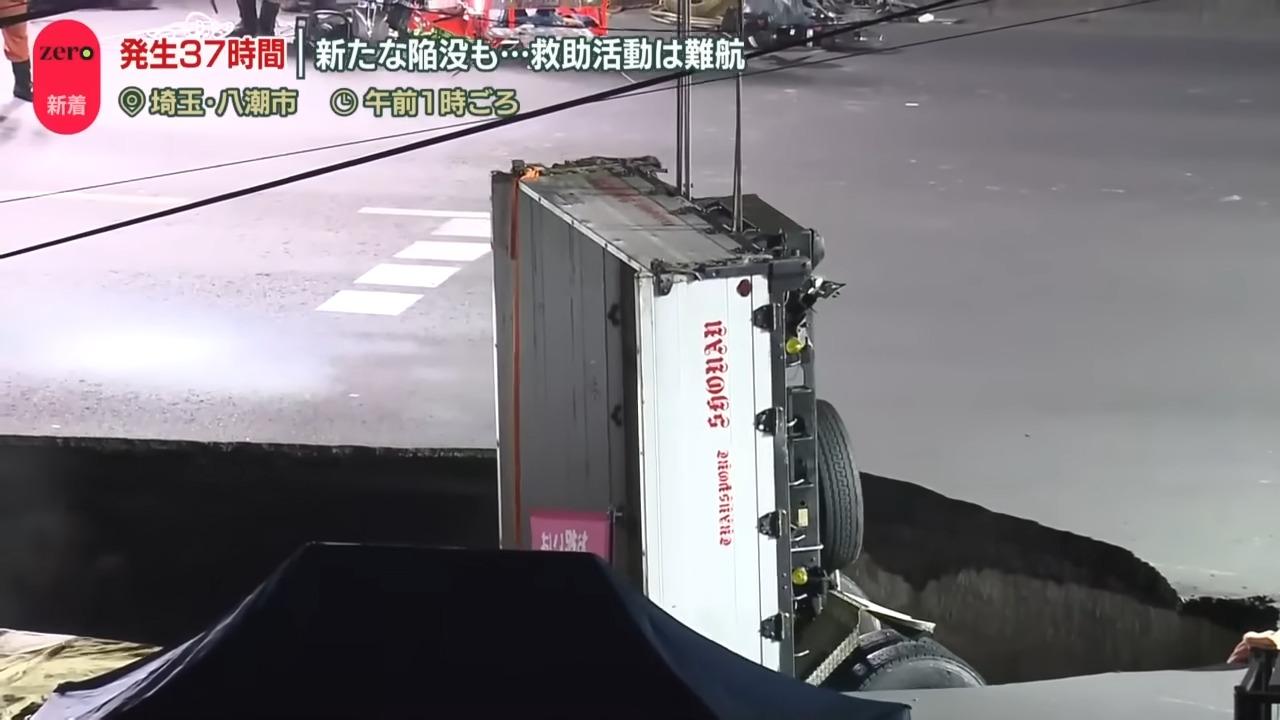 日本埼玉馬路天坑二合一,當局吊起貨車車尾但車頭仍在天坑內。(網上截圖)