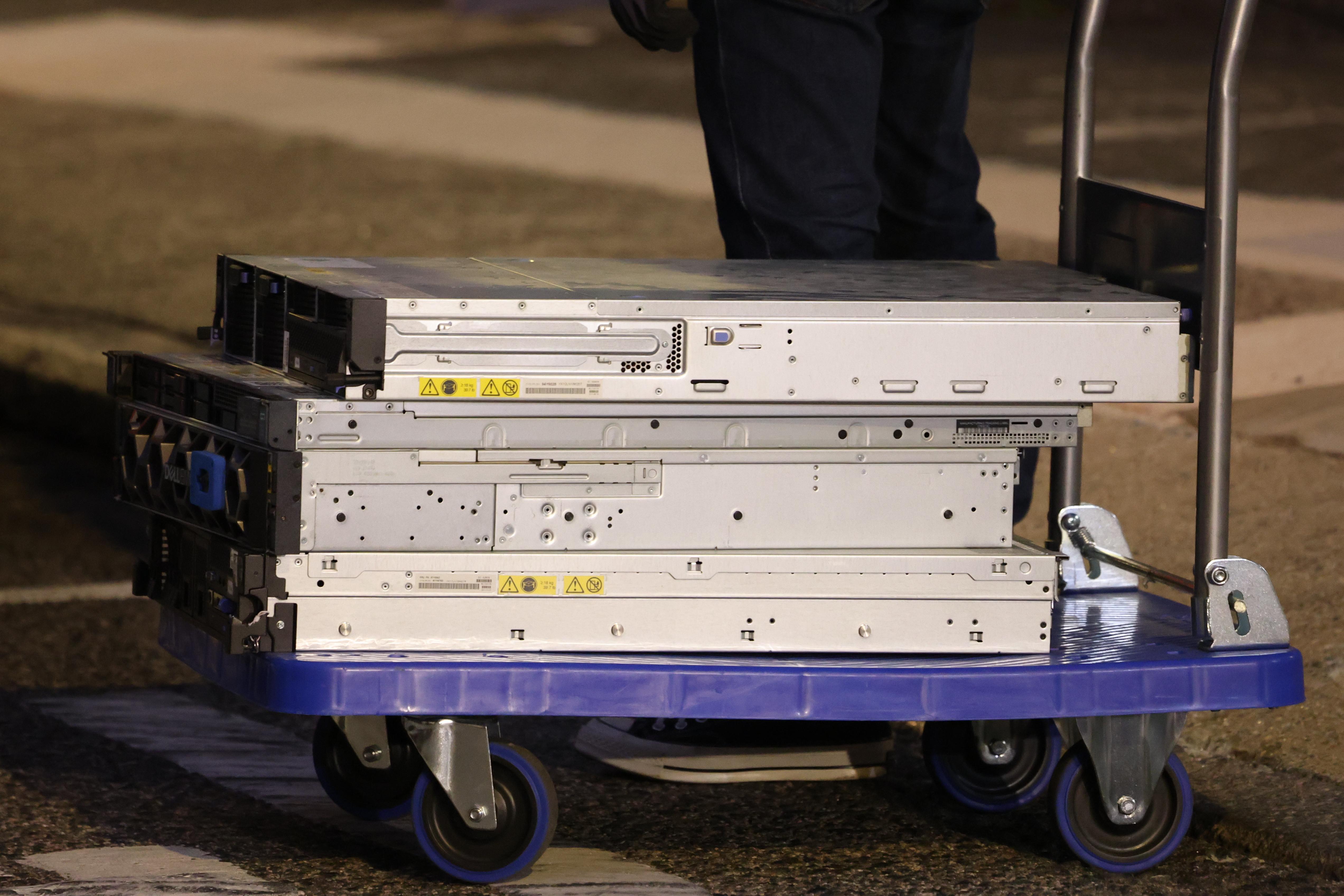 國安人員在民研辦公室搬走一批證物,包括約4部電腦主機,以及載滿至少6個大膠箱的物品。