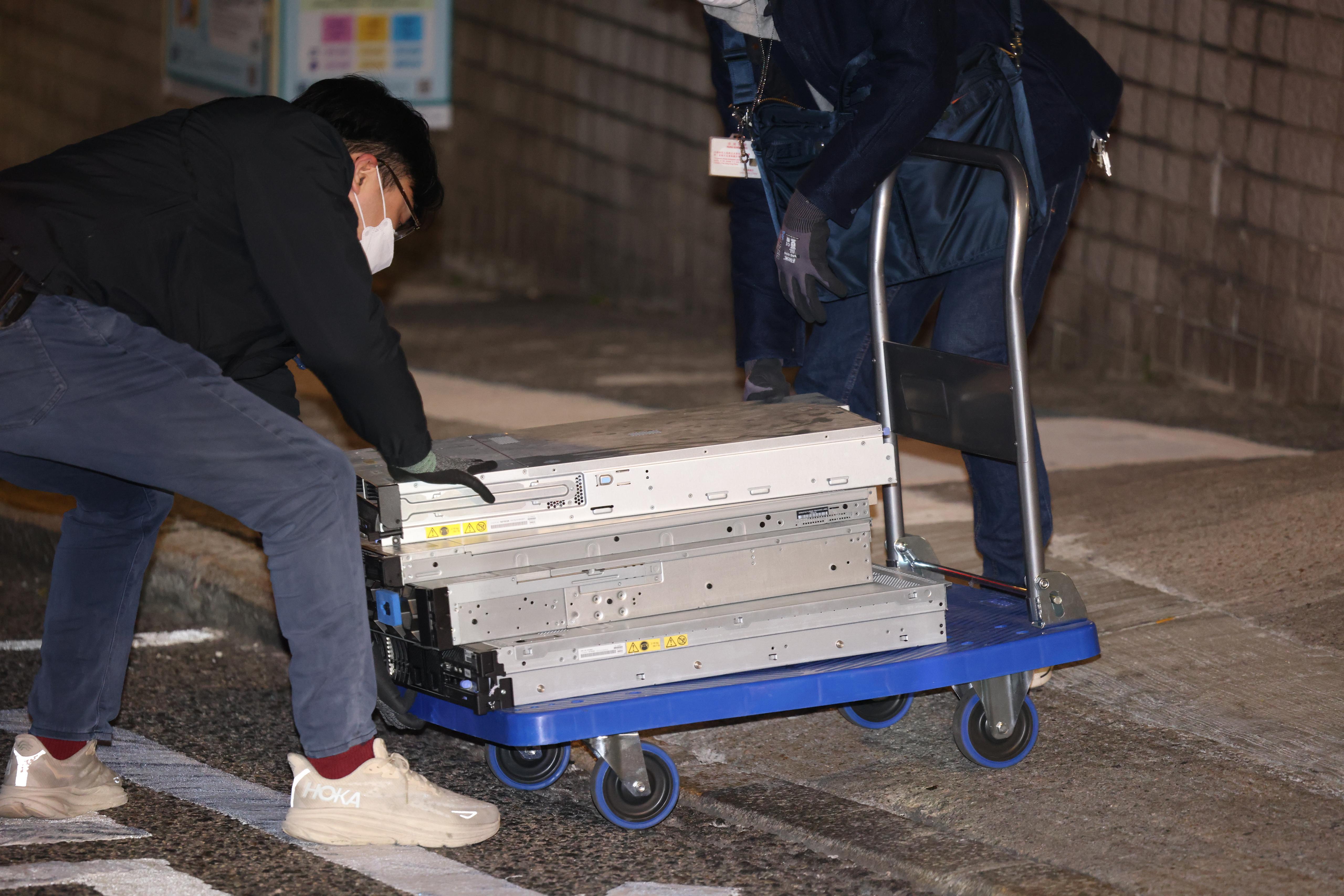 國安人員在民研辦公室搬走一批證物,包括約4部電腦主機,以及載滿至少6個大膠箱的物品。