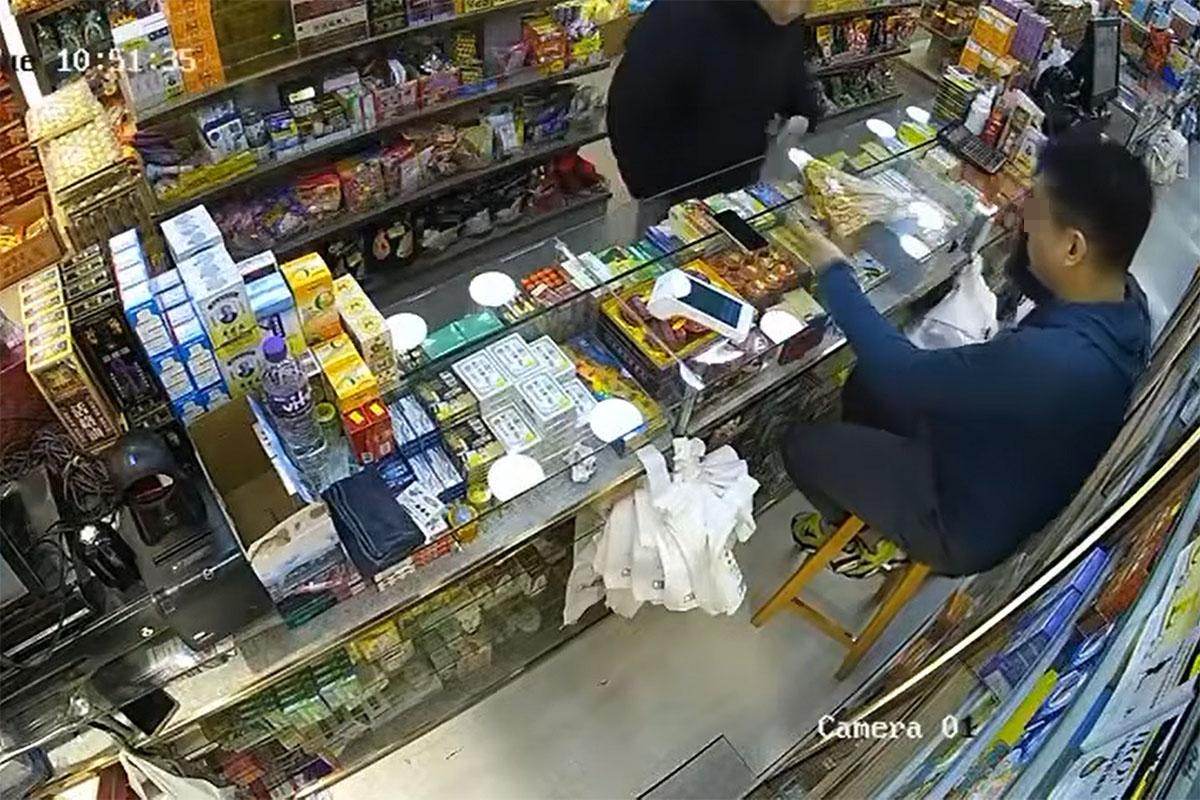 一名黑衣男子到藥坊內購買沙嗲魚串。(網上影片截圖)