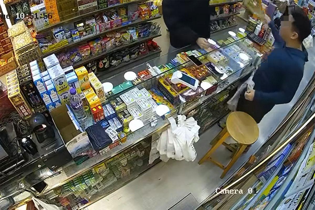 店員獲悉該張為偽鈔後折返,取起沙嗲魚串作勢打向男子。(網上影片截圖)