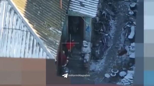 兩名穿紅衣的居民被趕出家門,其中一人跟已入屋的士兵對話。(互聯網)